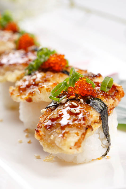 鳗鱼天妇罗手握寿司摆放在寿司帘上图片