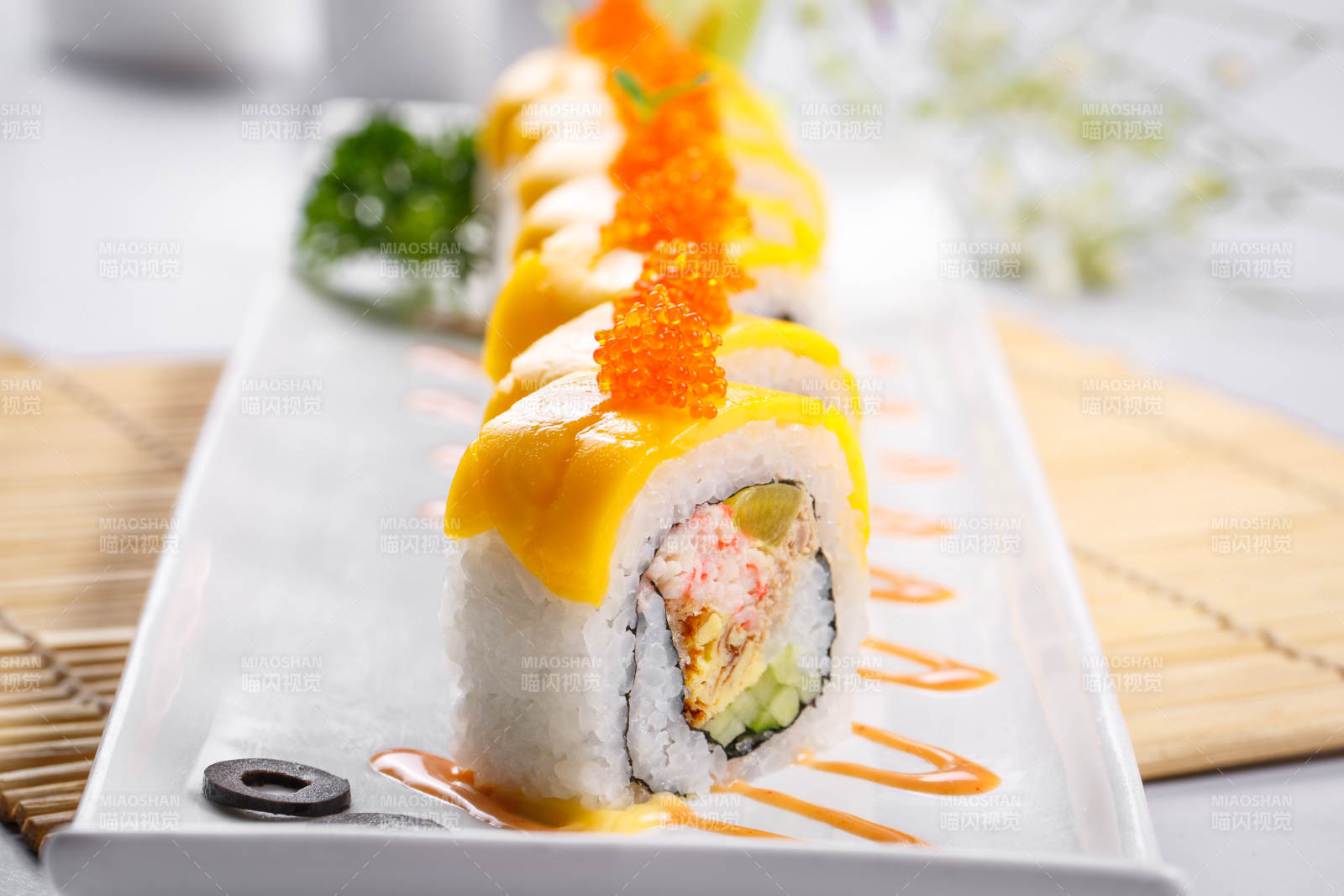 黄金甲蟹子寿司卷摆放在寿司帘上图片