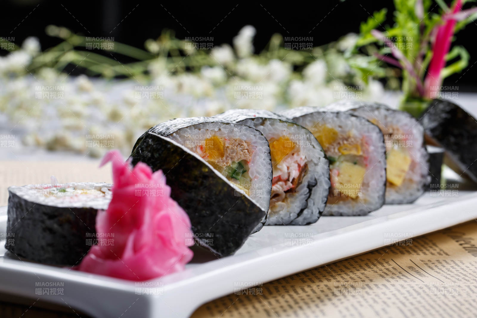 什锦太手卷寿司摆放在英文包装纸上图片