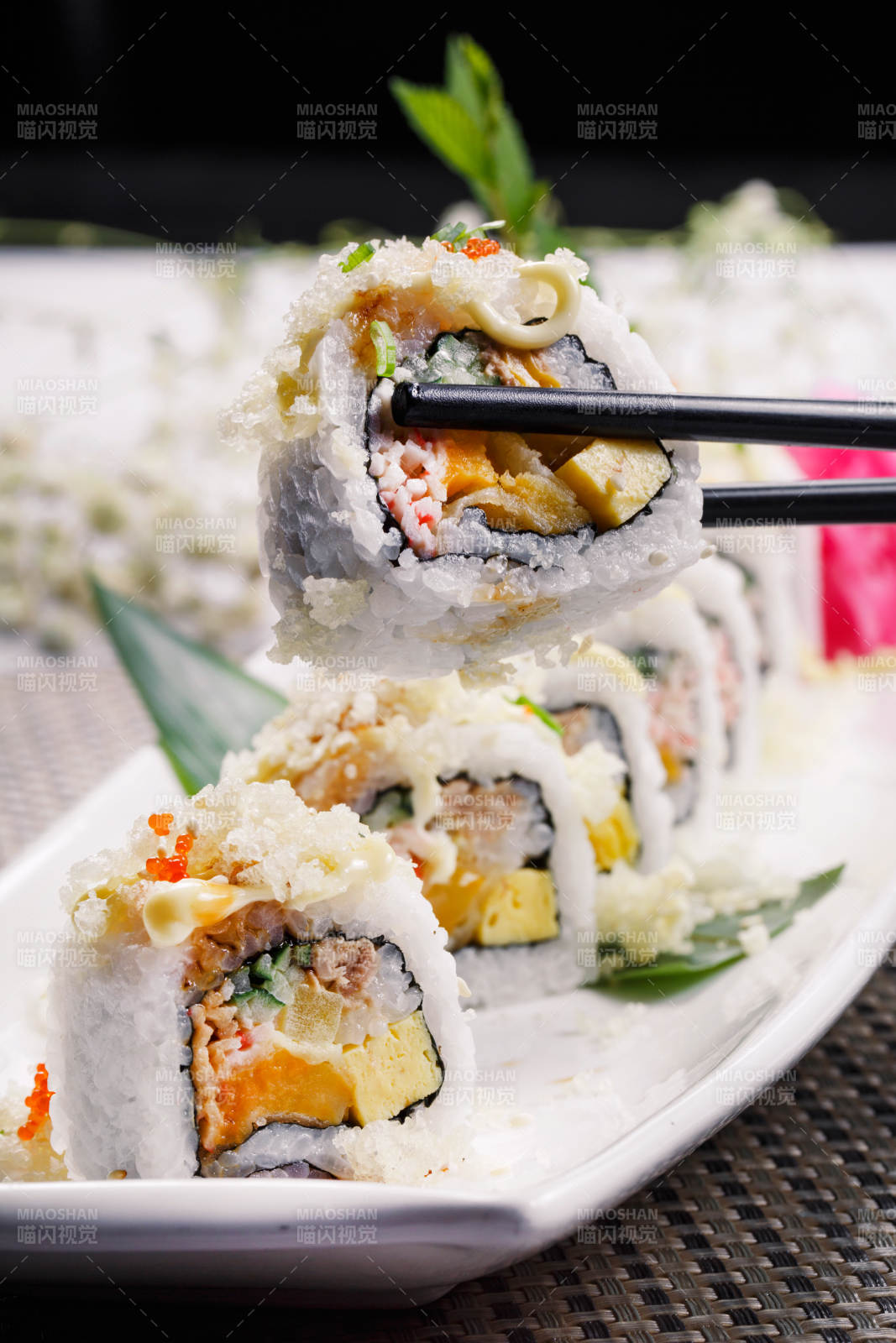 长方形瓷盘装的脆脆卷寿司摆放在餐垫上图片