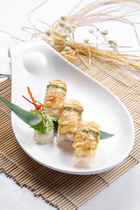 芝士焗鲜虾手握寿司摆放在寿司帘上图片