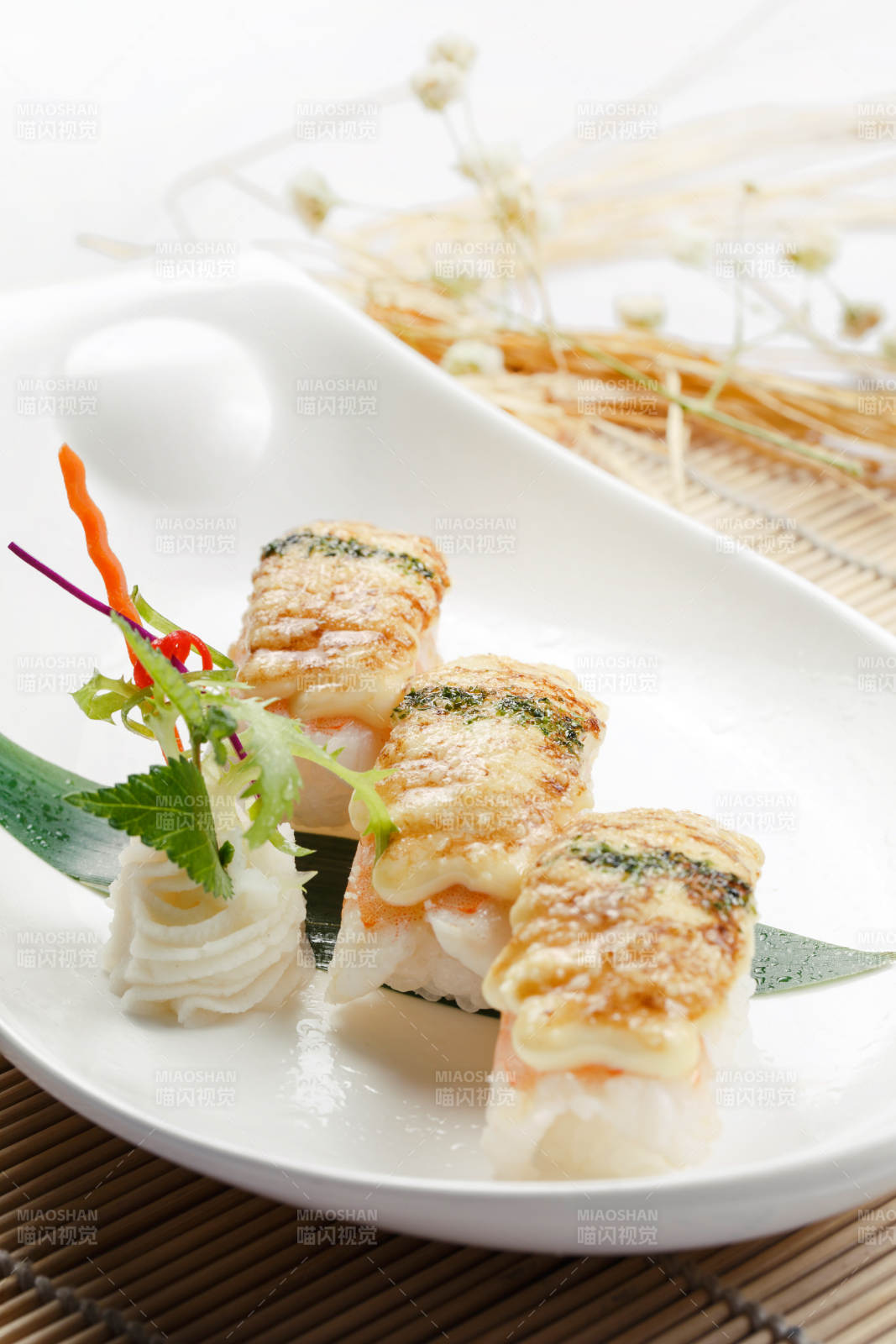 芝士焗鲜虾手握寿司摆放在寿司帘上图片