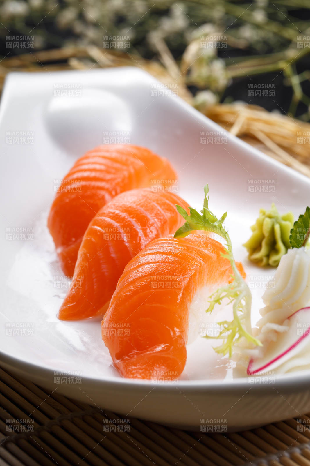 三文鱼手握寿司摆放在寿司帘上图片