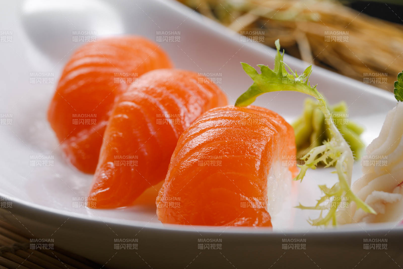 三文鱼手握寿司摆放在寿司帘上图片