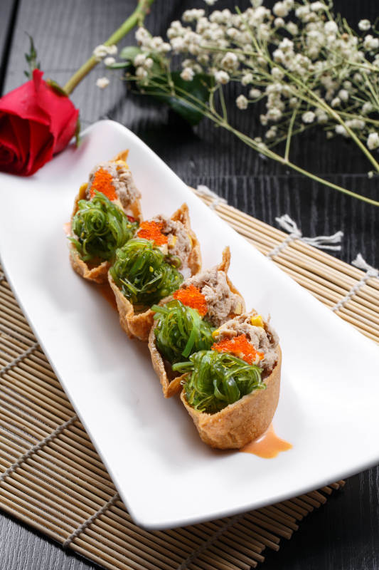 黄金船脆皮寿司摆放在寿司帘上图片