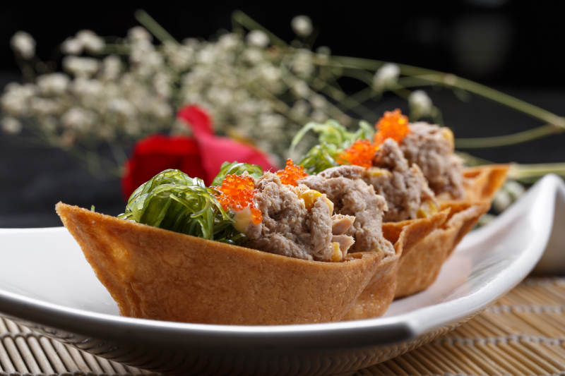 黄金船脆皮寿司摆放在寿司帘上图片