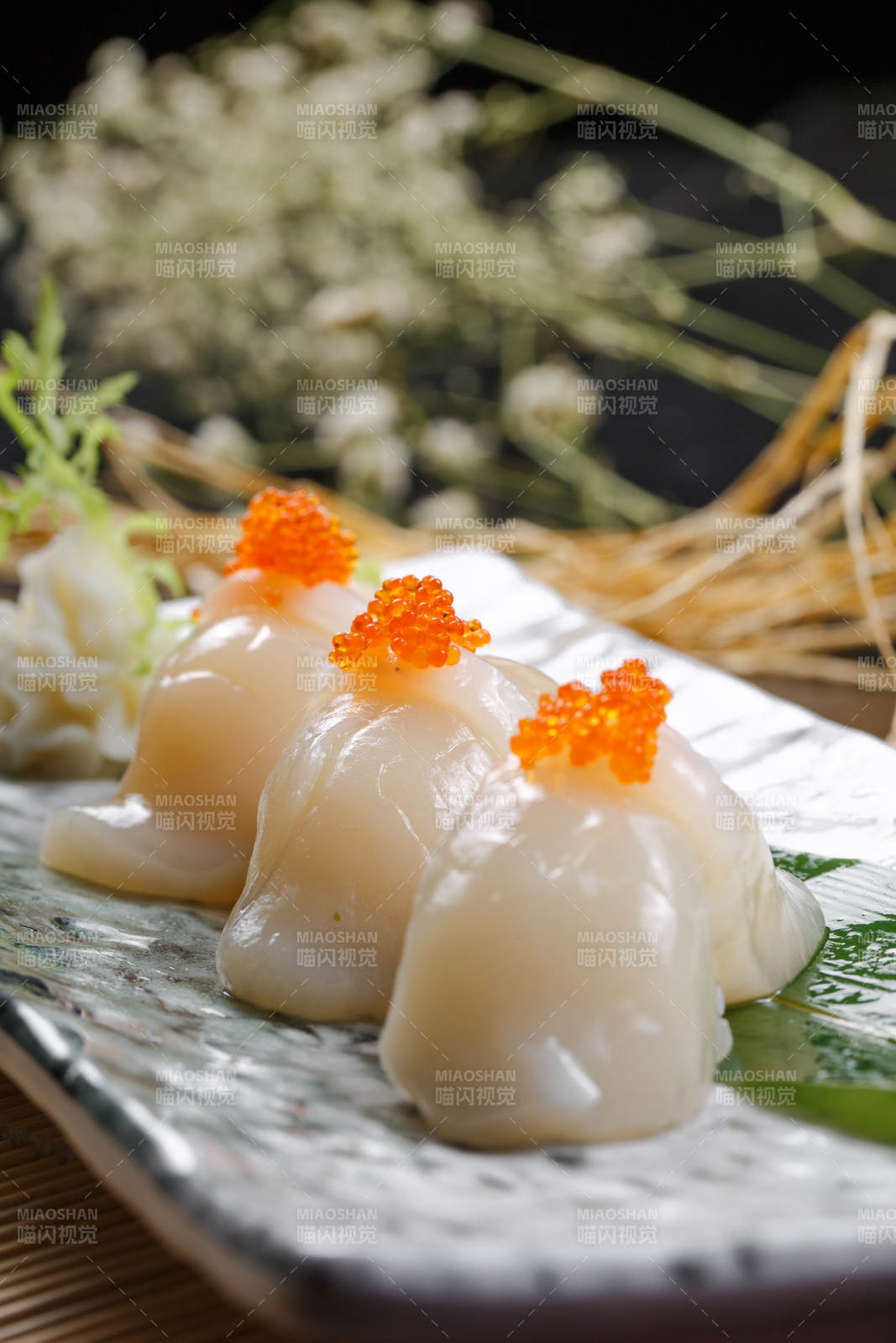 照烧带子蟹子手握寿司摆放在寿司帘上图片