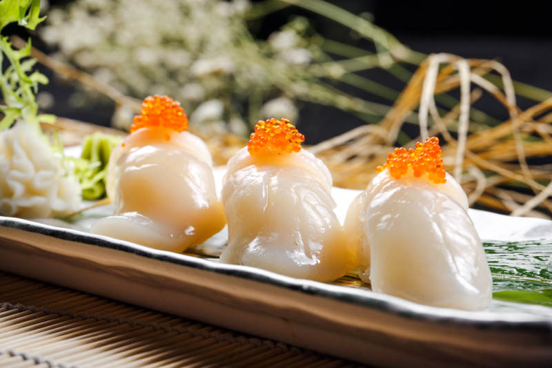 照烧带子蟹子手握寿司摆放在寿司帘上图片