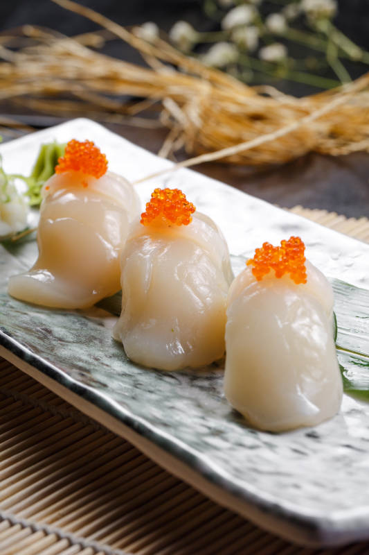 照烧带子蟹子手握寿司摆放在寿司帘上图片