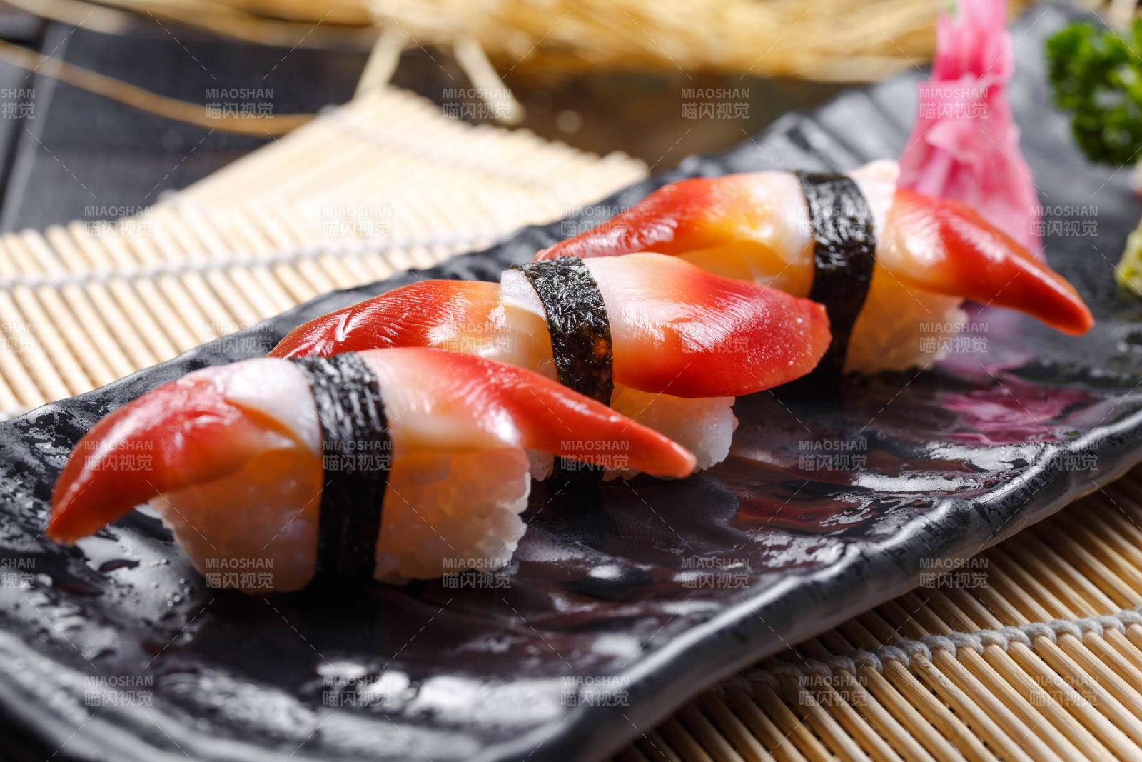 北极贝手握寿司摆放在寿司帘上图片