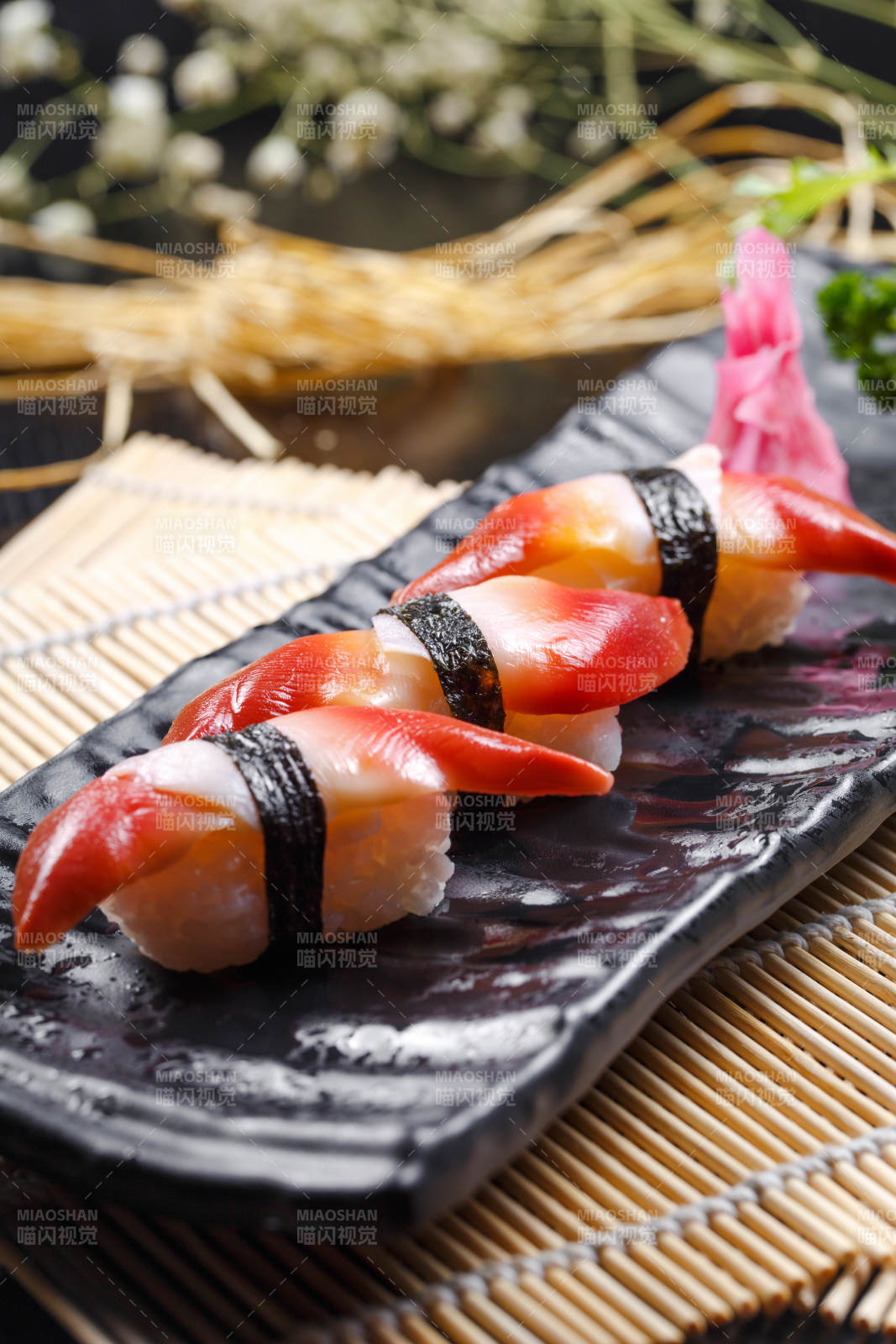 北极贝手握寿司摆放在寿司帘上图片