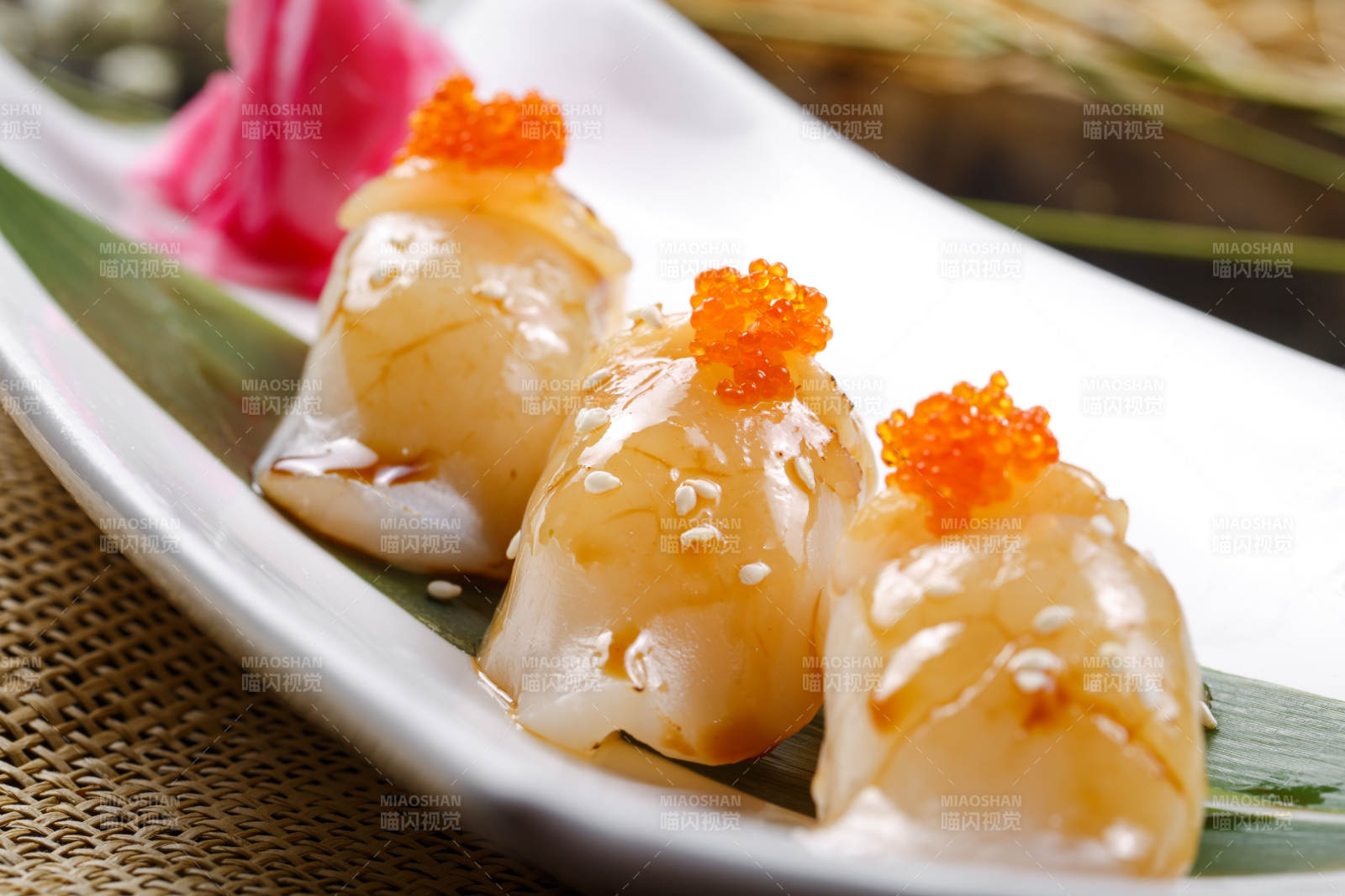 照烧带子蟹子手握寿司摆放在寿司帘上图片