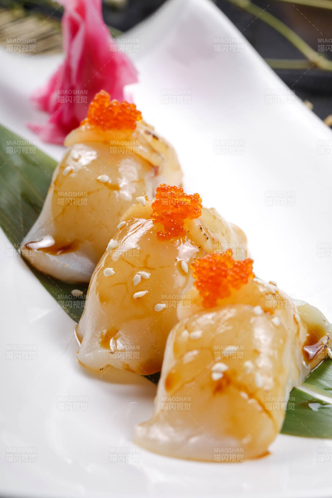 照烧带子蟹子手握寿司摆放在寿司帘上图片