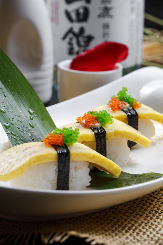 玉子小姐海苔蛋烧手握寿司摆放在草垫上图片