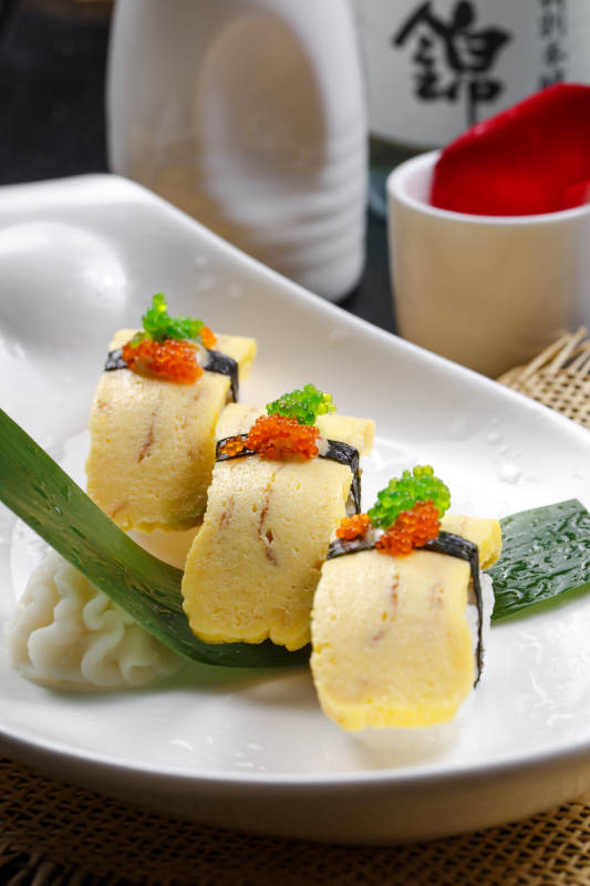 玉子小姐海苔蛋烧手握寿司摆放在草垫上图片