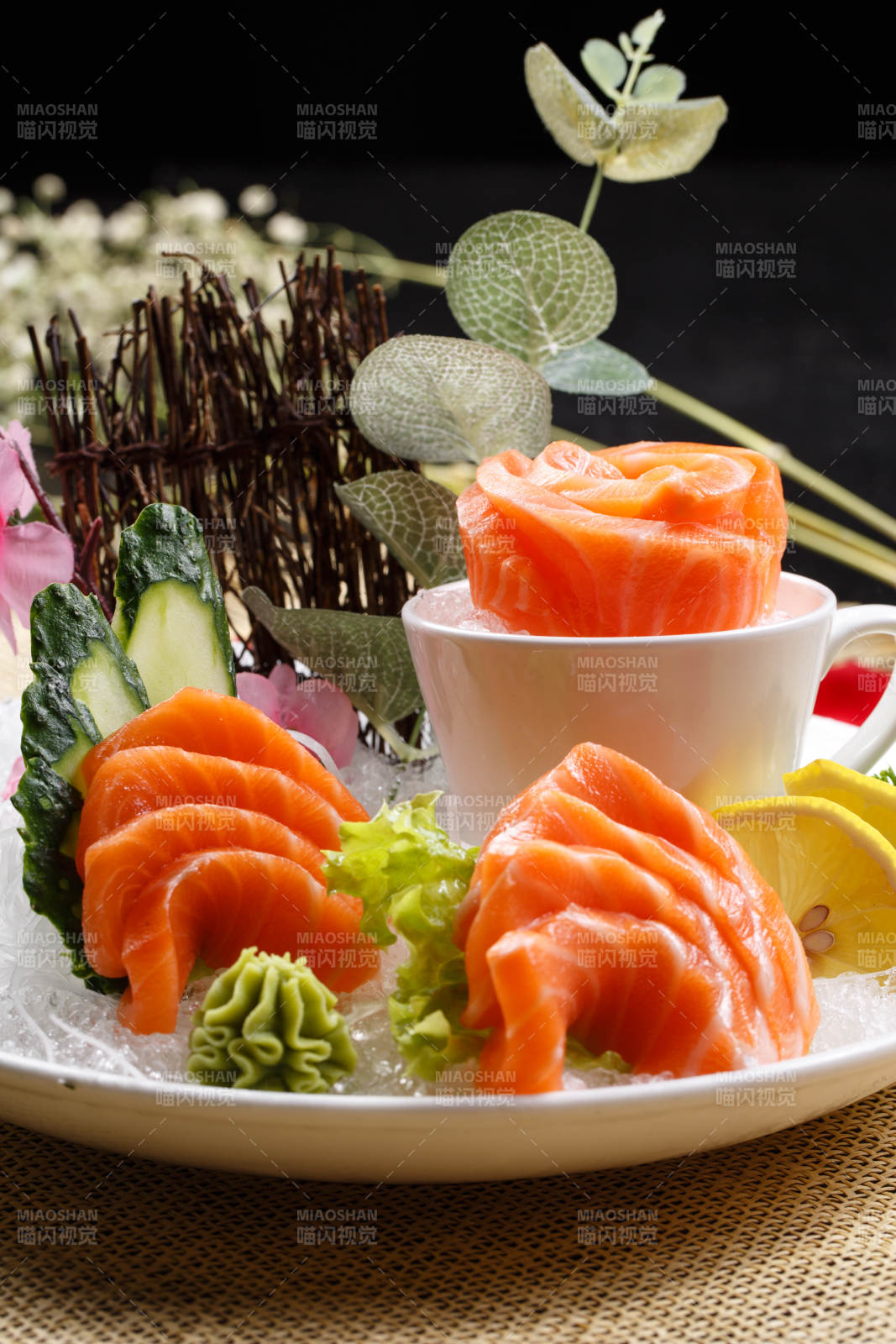 三文鱼刺身摆放在草垫上图片