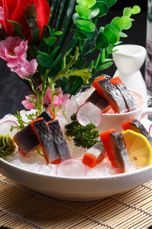 西鳞鱼刺身摆放在寿司帘上图片