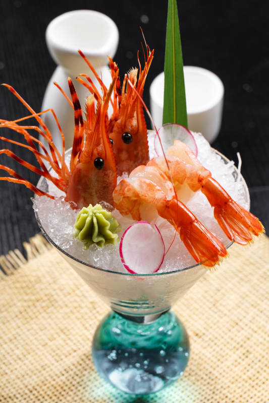 装满碎冰的高脚杯摆放的两只北极甜虾刺身图片