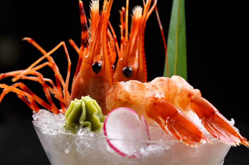 装满碎冰的高脚杯摆放的两只北极甜虾刺身图片