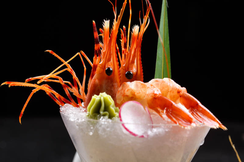 装满碎冰的高脚杯摆放的两只北极甜虾刺身图片