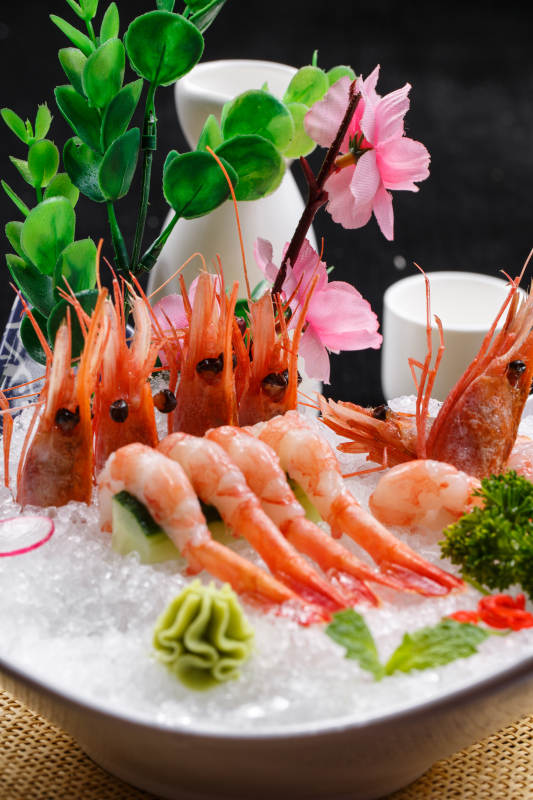 北极甜虾刺身摆放在草垫上图片