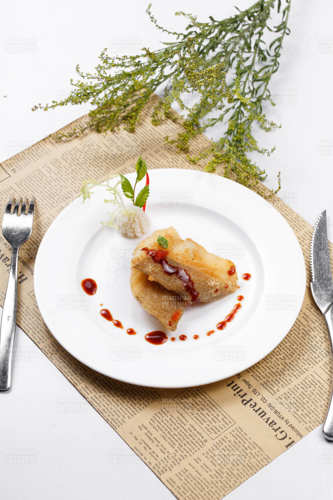 铁板煎格陵兰鳕鱼摆放在英文包装纸上图片