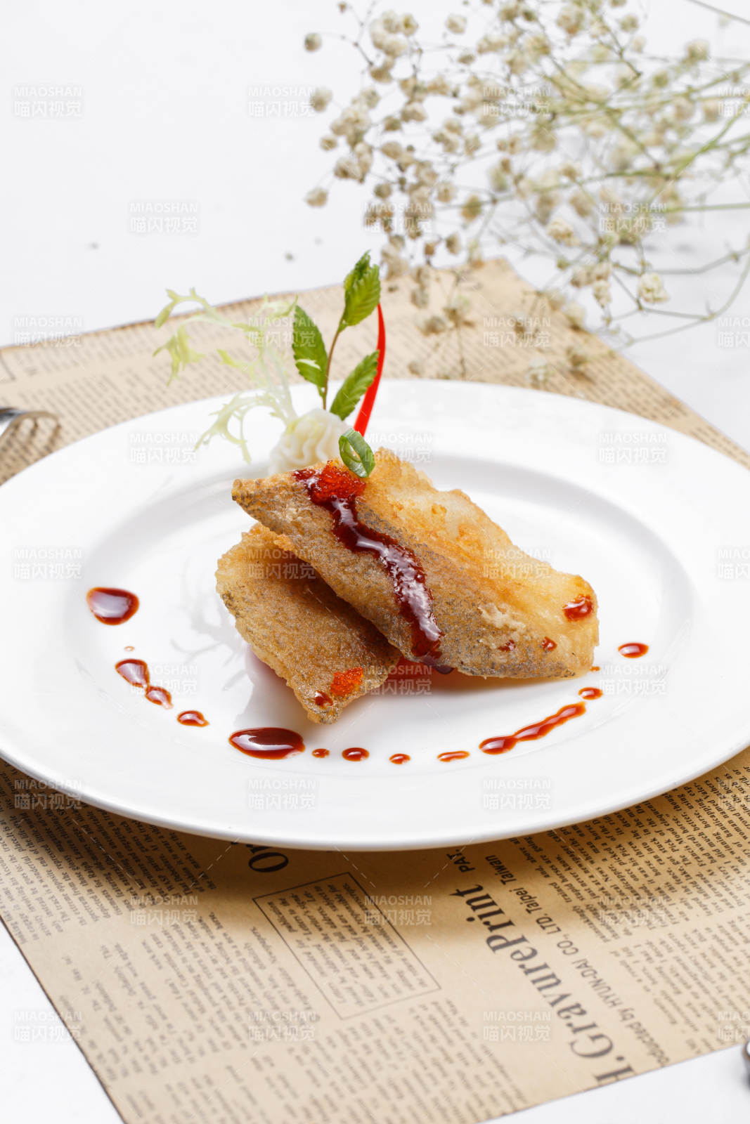 铁板煎格陵兰鳕鱼摆放在英文包装纸上图片