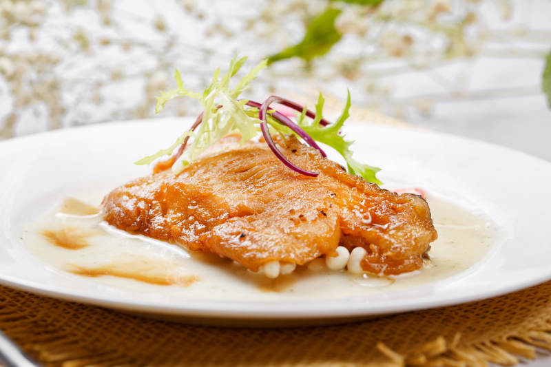 铁板照烧汁煎银鳕鱼摆放在草垫上图片