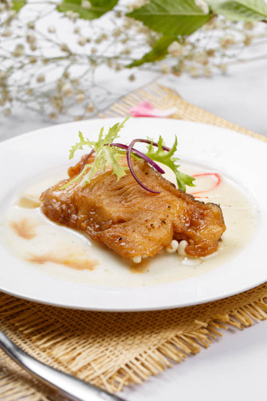 铁板照烧汁煎银鳕鱼摆放在草垫上图片