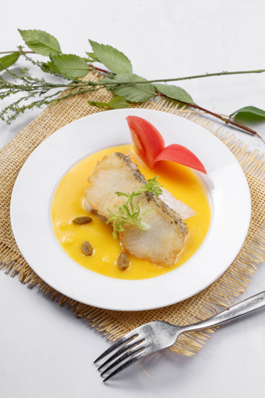 银鳕鱼佐法式南瓜酱摆放在草垫上图片