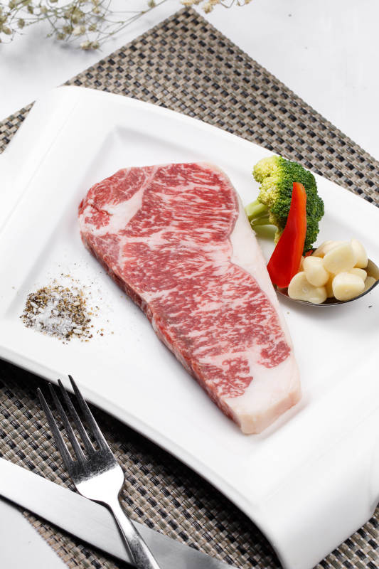 顶级A5A3级雪花牛排摆放在餐垫上图片