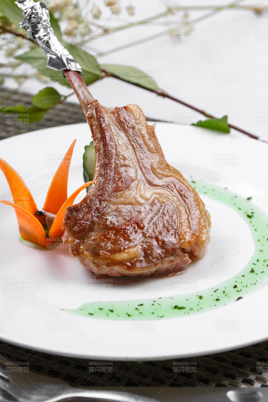 圆形白瓷盘装的波尔多法式铁板羊排摆放在餐垫上图片