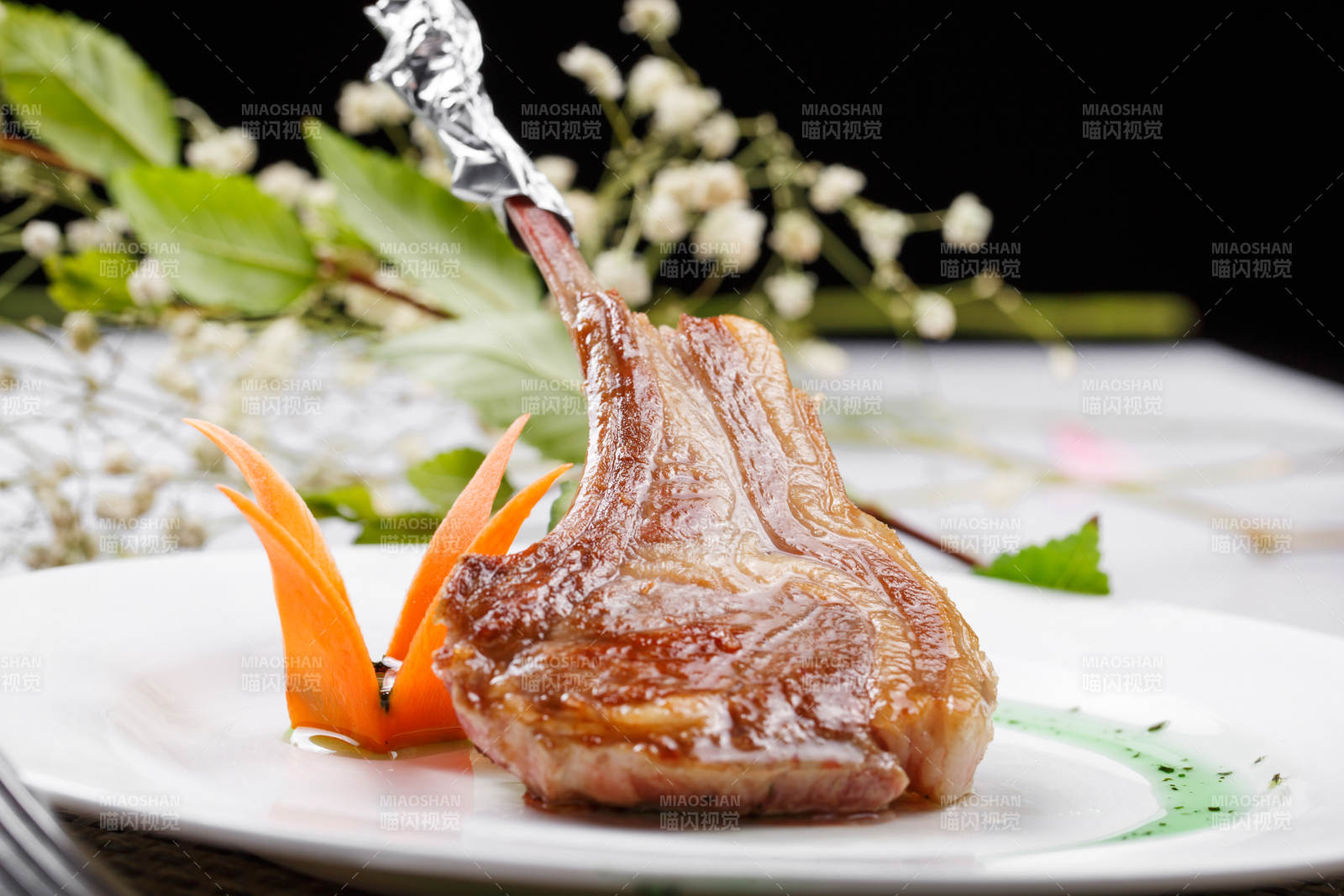 圆形白瓷盘装的波尔多法式铁板羊排摆放在餐垫上图片