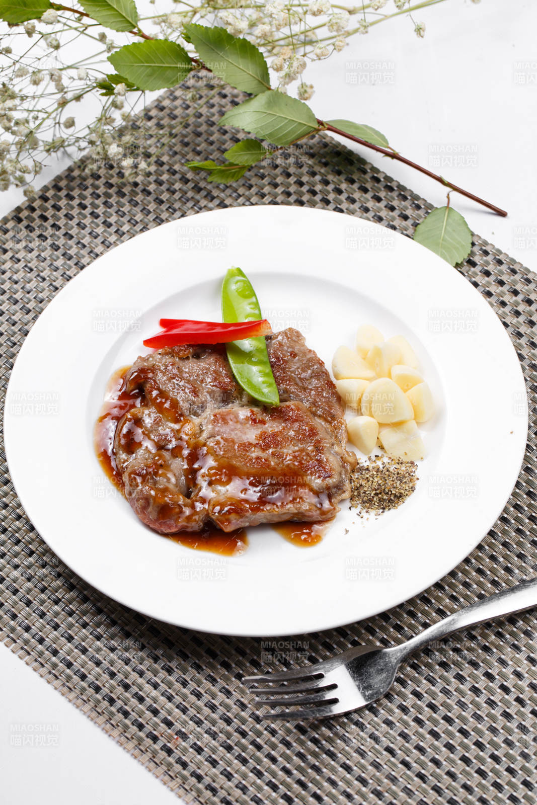 黑椒酱铁板煎蒜香猪排摆放在餐垫上图片