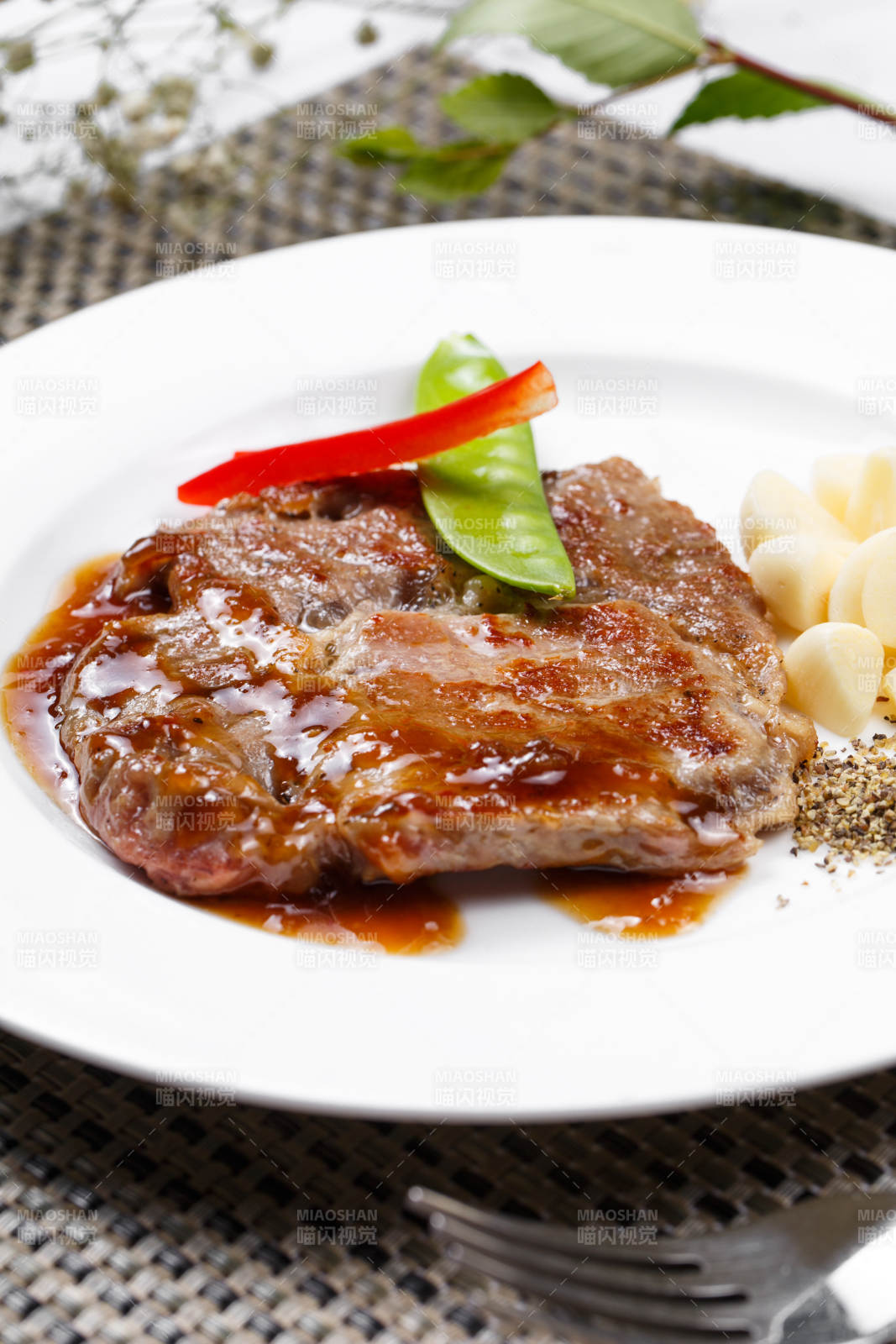 黑椒酱铁板煎蒜香猪排摆放在餐垫上图片