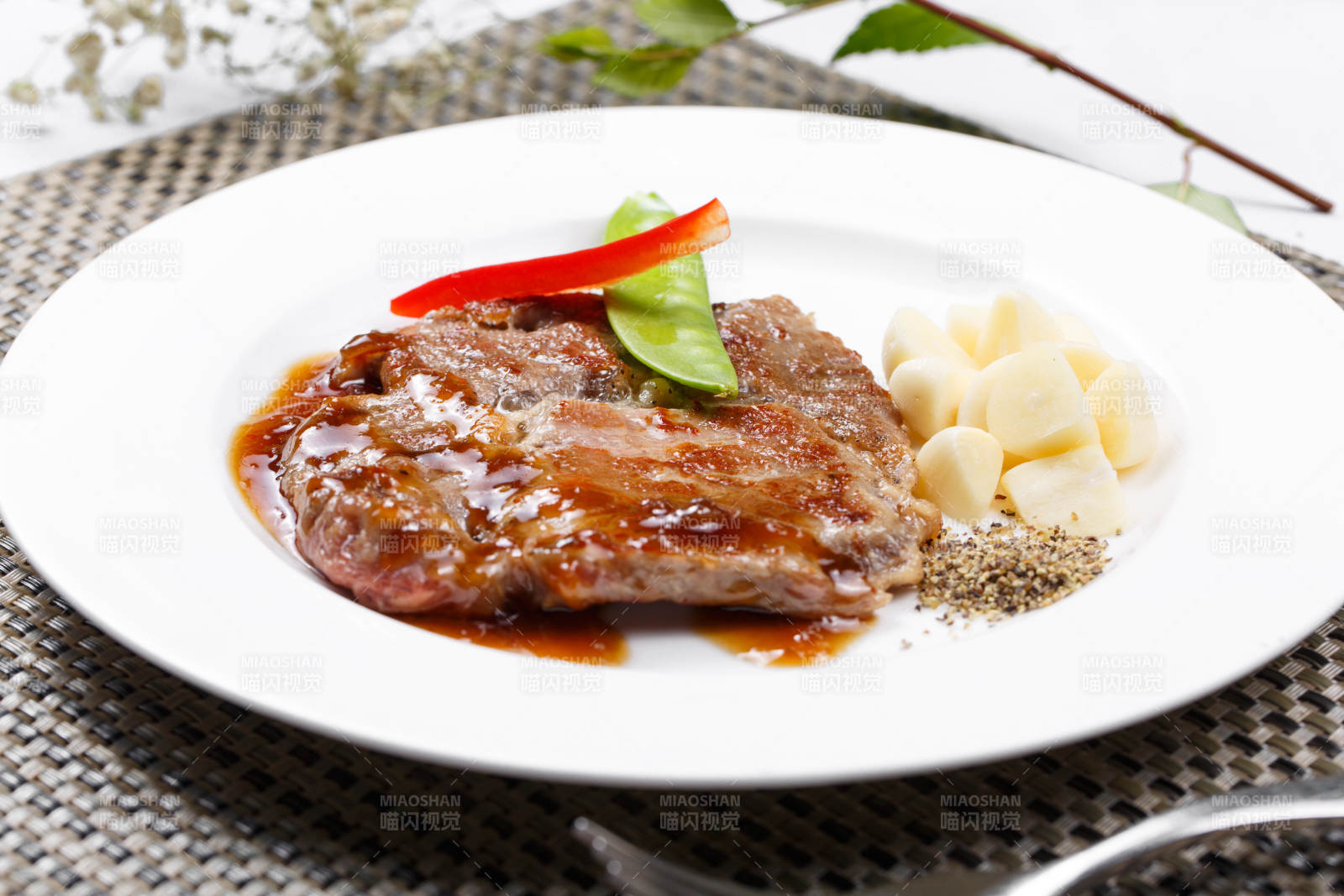 黑椒酱铁板煎蒜香猪排摆放在餐垫上图片