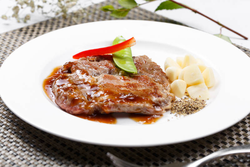 黑椒酱铁板煎蒜香猪排摆放在餐垫上图片