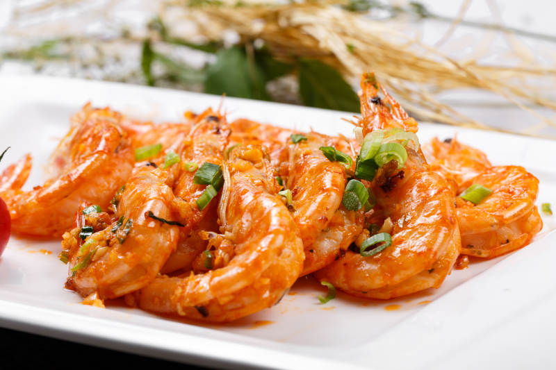 铁板开背南美虾摆放在餐垫上图片