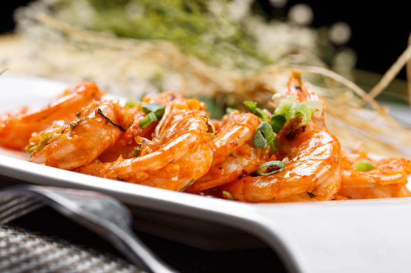 铁板开背南美虾摆放在餐垫上图片