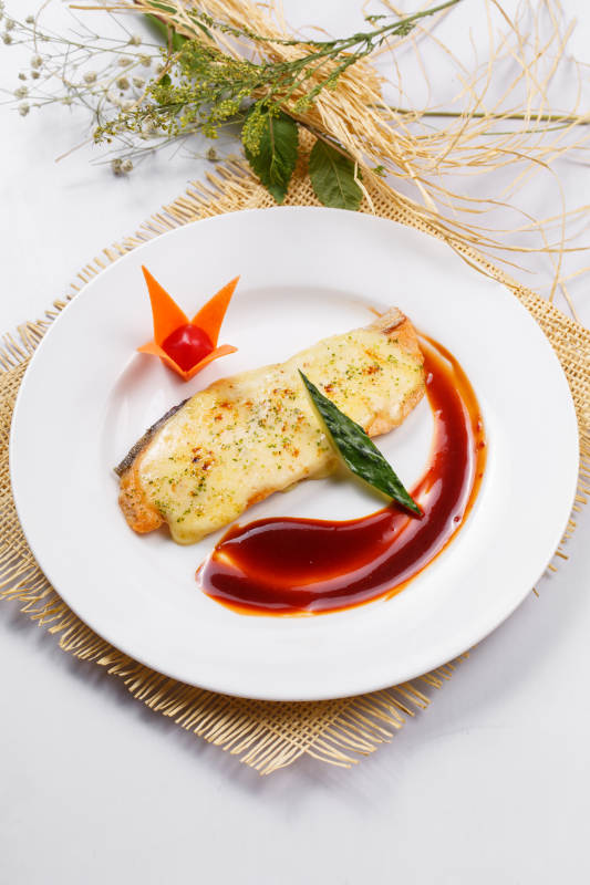 芝士焗挪威三文鱼佐红酒酱摆放在草垫上图片