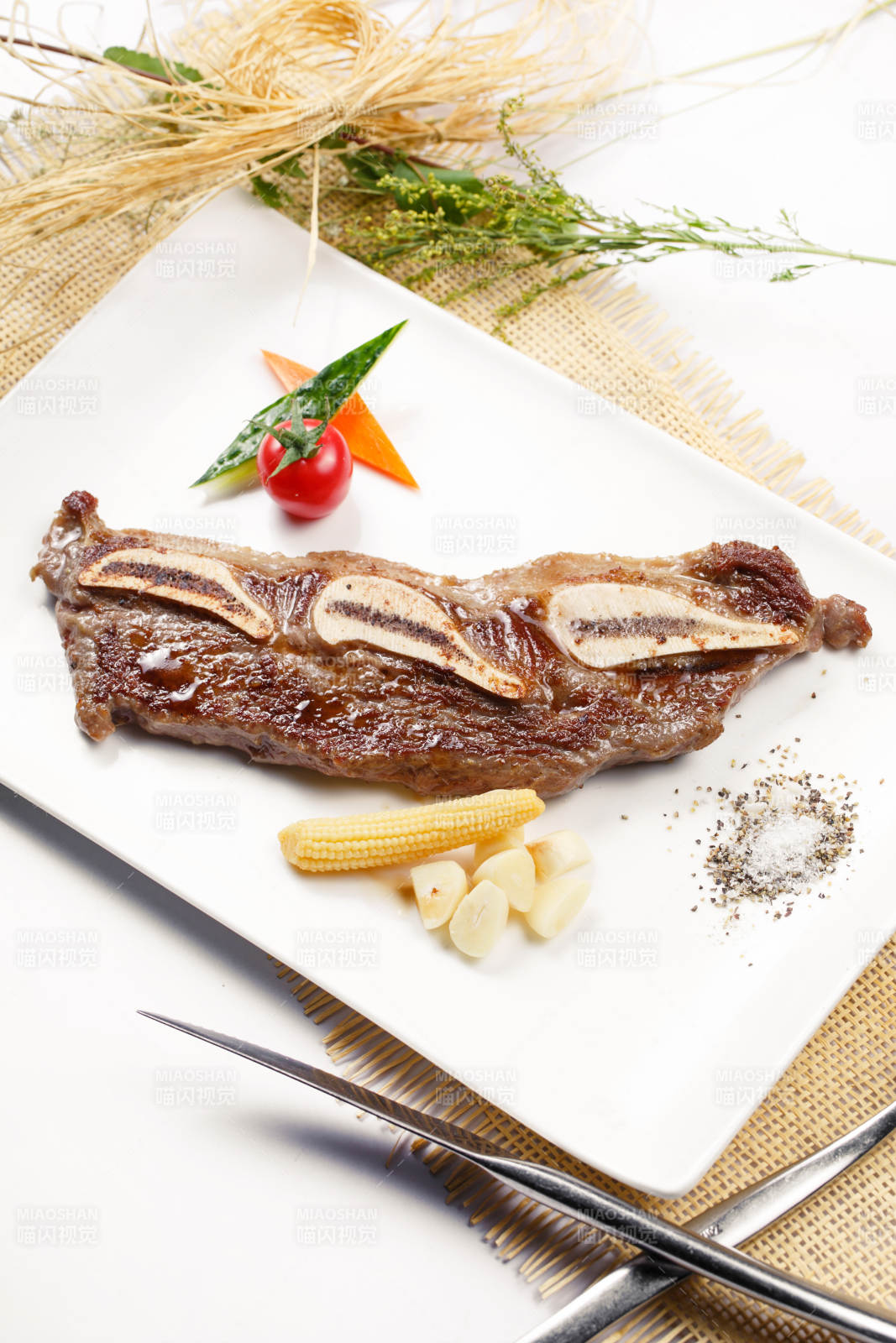 日式铁板带骨小牛排摆放在草垫上图片