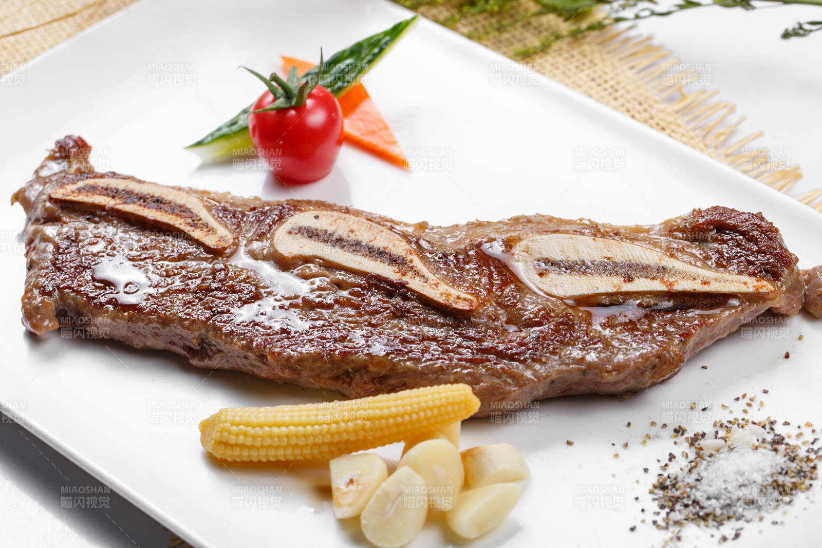 日式铁板带骨小牛排摆放在草垫上图片