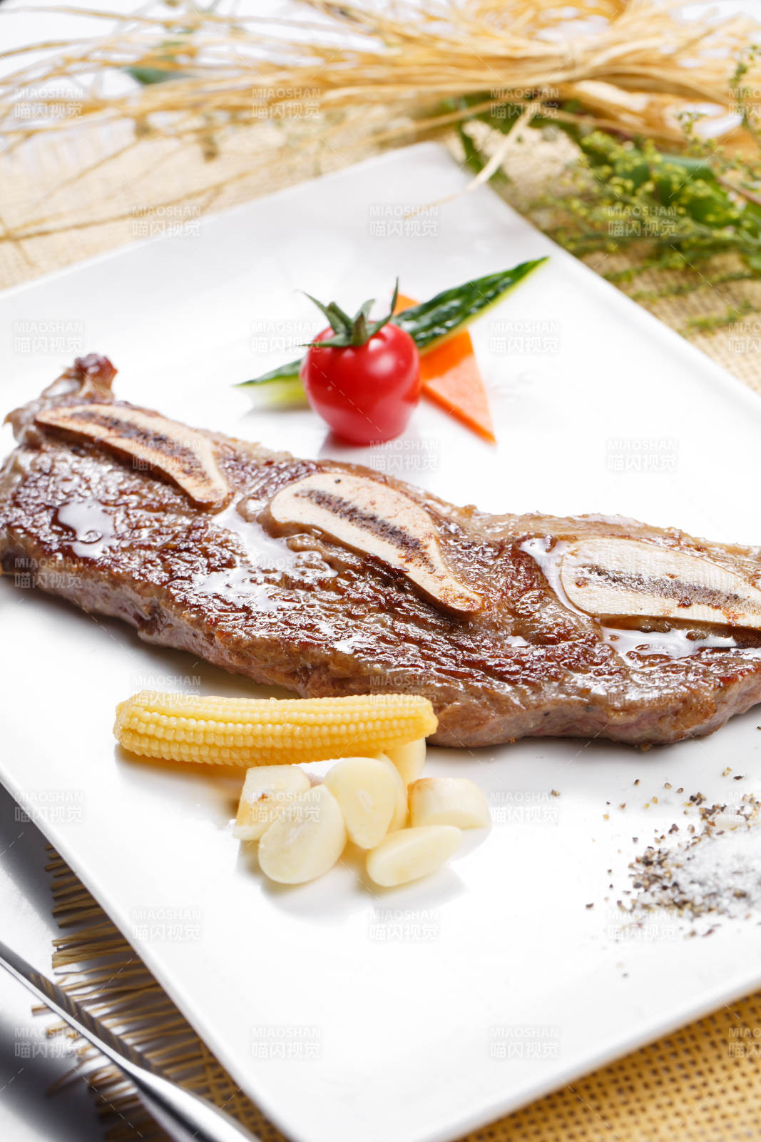 日式铁板带骨小牛排摆放在草垫上图片