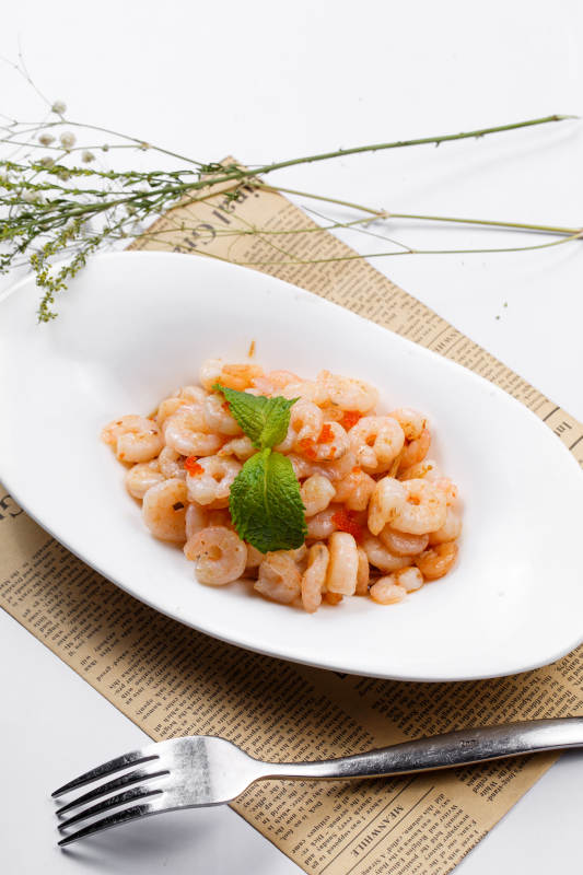 铁板虾仁金针菇摆放在英文包装纸上图片