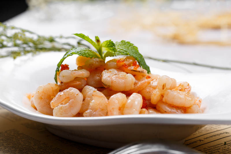 铁板虾仁金针菇摆放在英文包装纸上图片