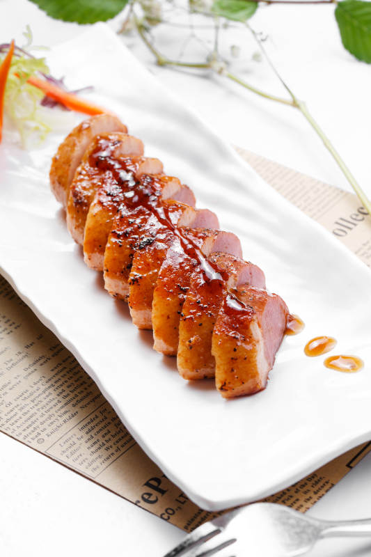 黑胡椒酱铁板鸭脯肉摆放在英文包装纸上图片