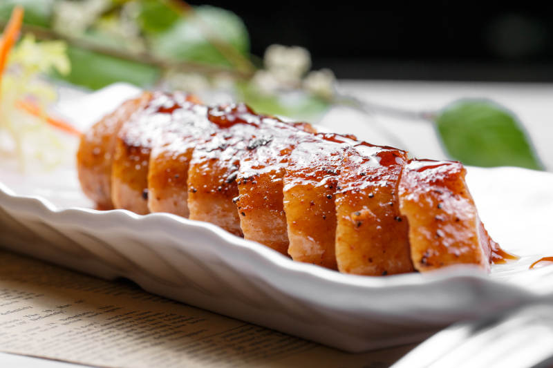 黑胡椒酱铁板鸭脯肉摆放在英文包装纸上图片