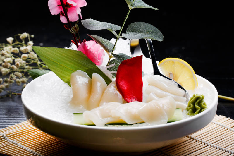 鲜带子刺身摆放在寿司帘上图片