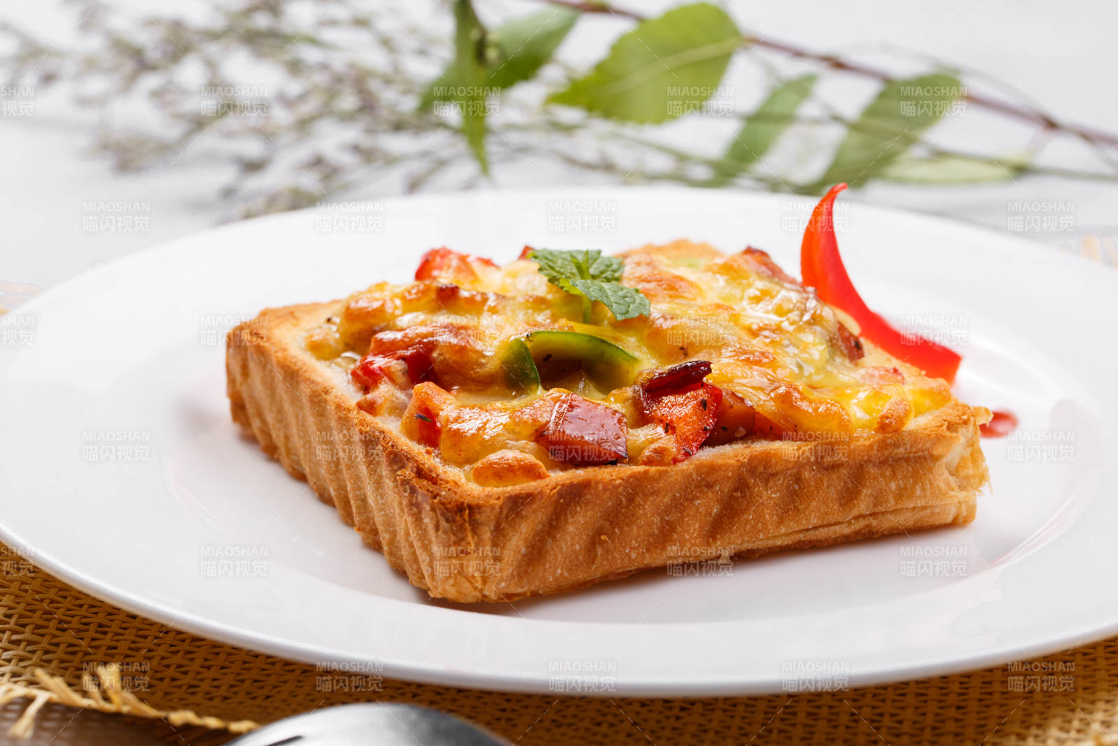 白色圆盘装现烤海鲜牛肉小披萨摆放在草垫上图片