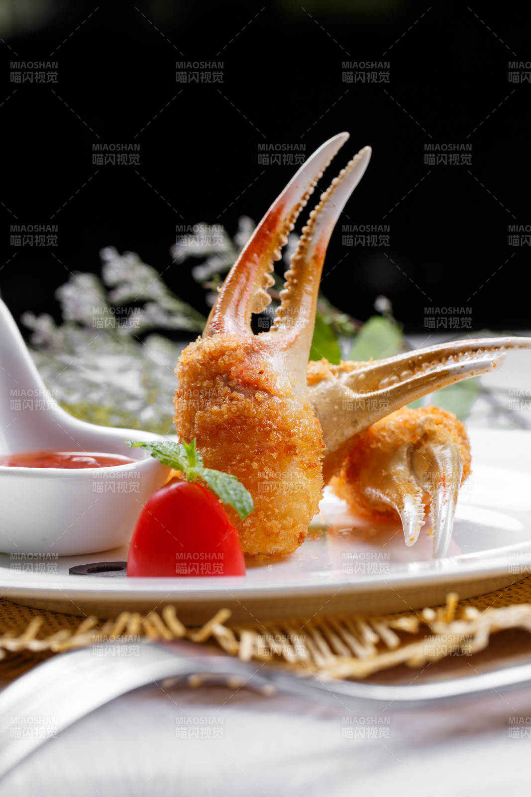 白色圆盘装面包糠芝士焗梭蟹钳摆放在草垫上图片